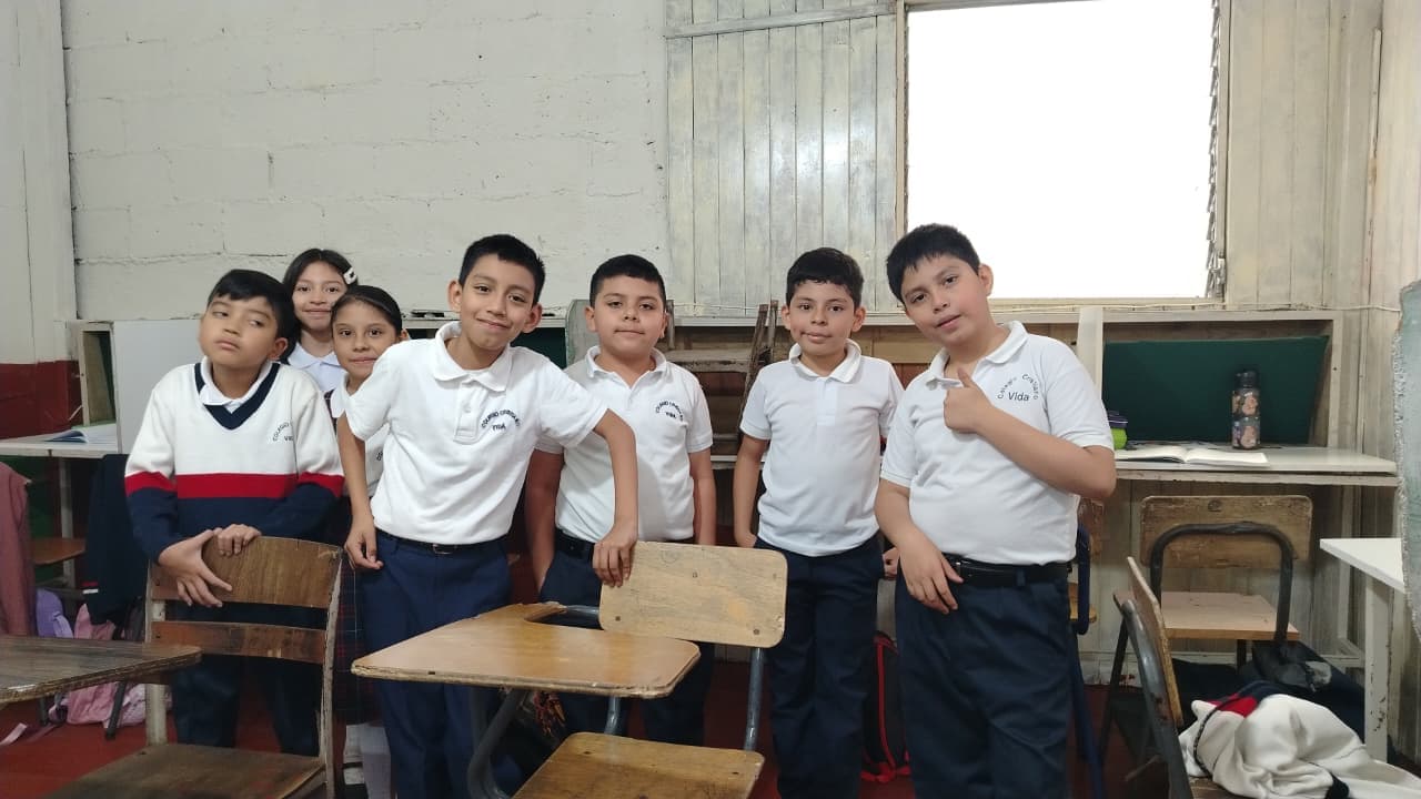 Colegio Vida students gathered beside their classroom desks