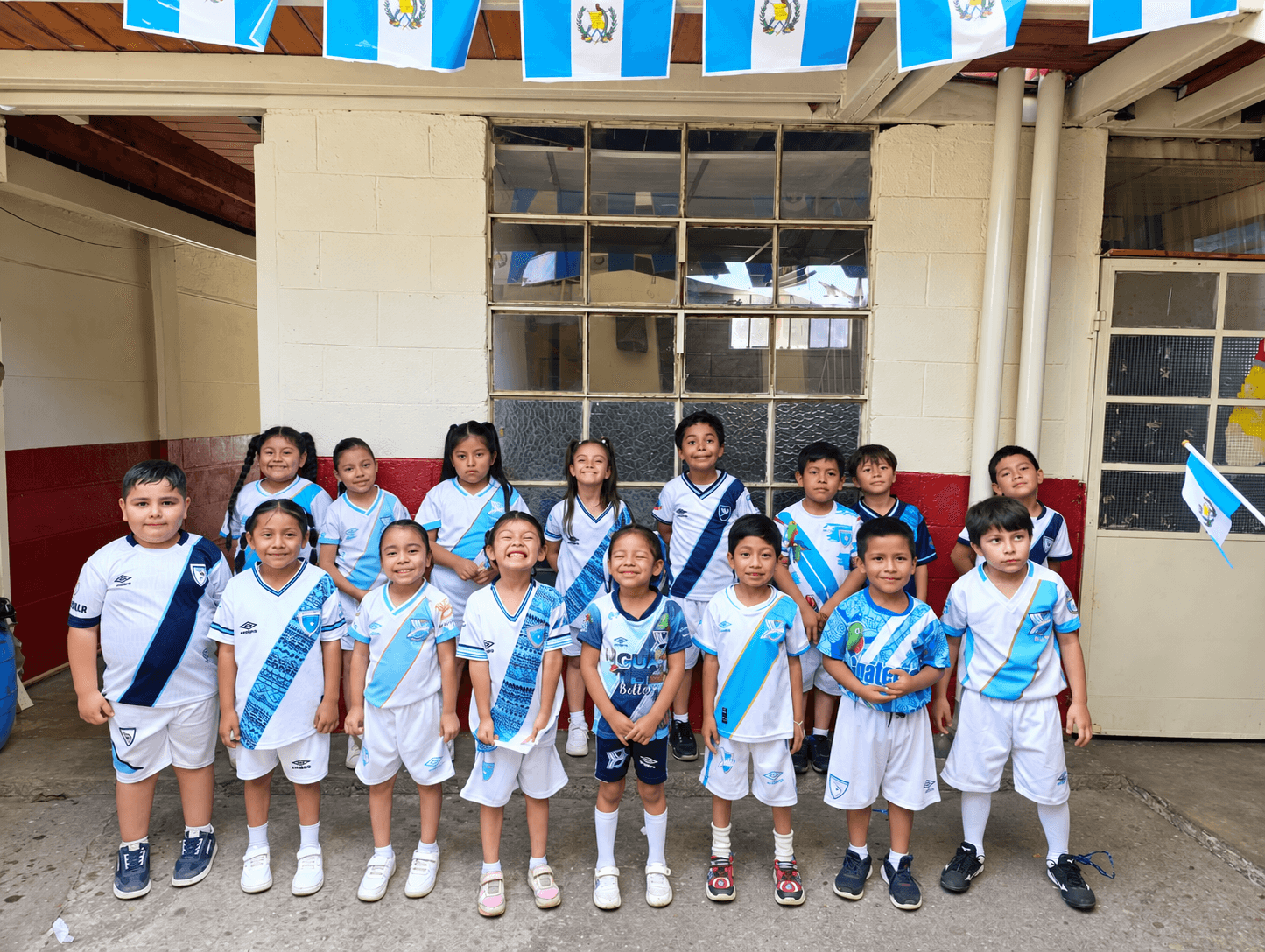 Students gathered beneath Guatemalan flags outside their school