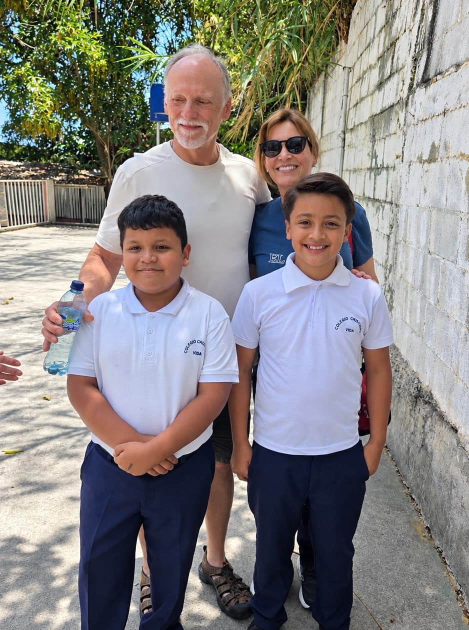 Two students and two adult visitors standing together outside