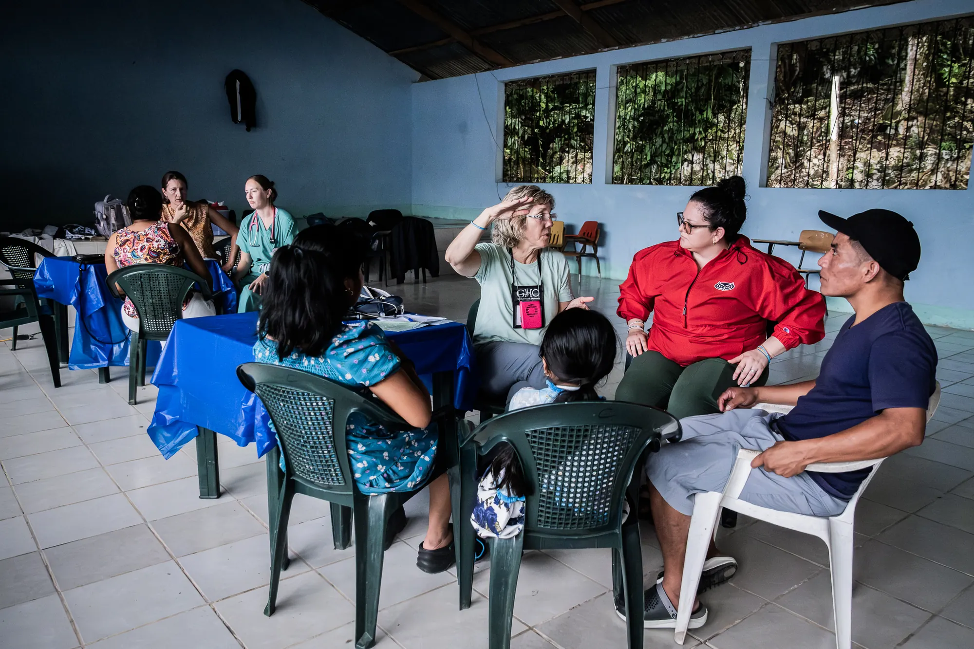 Voluntarios de atención médica escuchan a los residentes durante una clínica comunitaria.