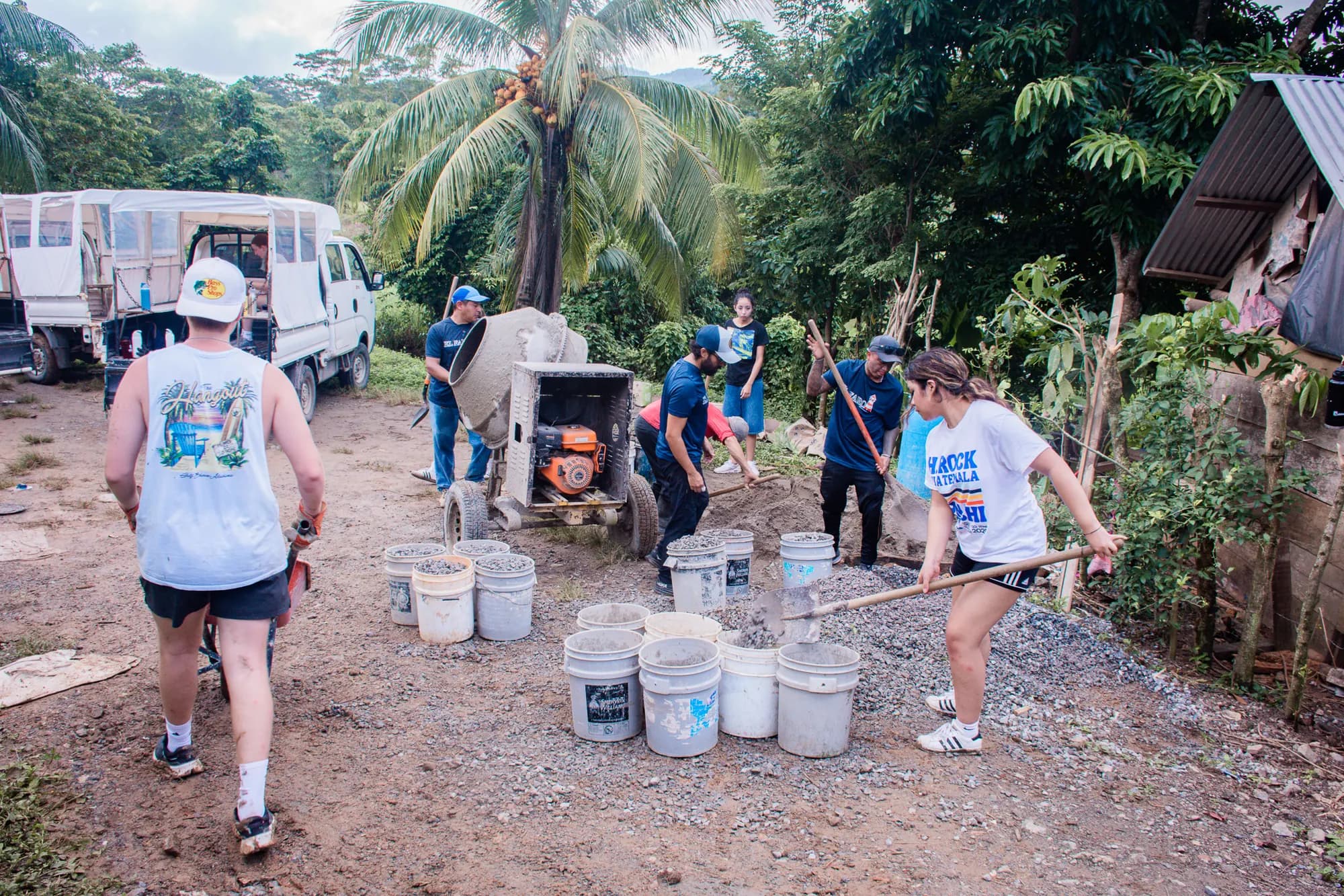Volunteers carry buckets and materials for a practical improvement project.