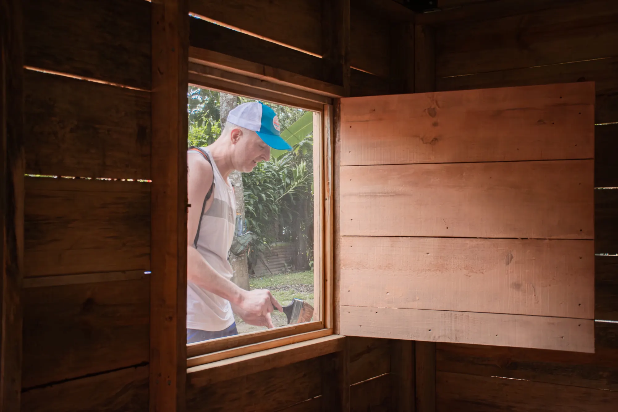 A volunteer paints inside a home during an El Faro mission trip.