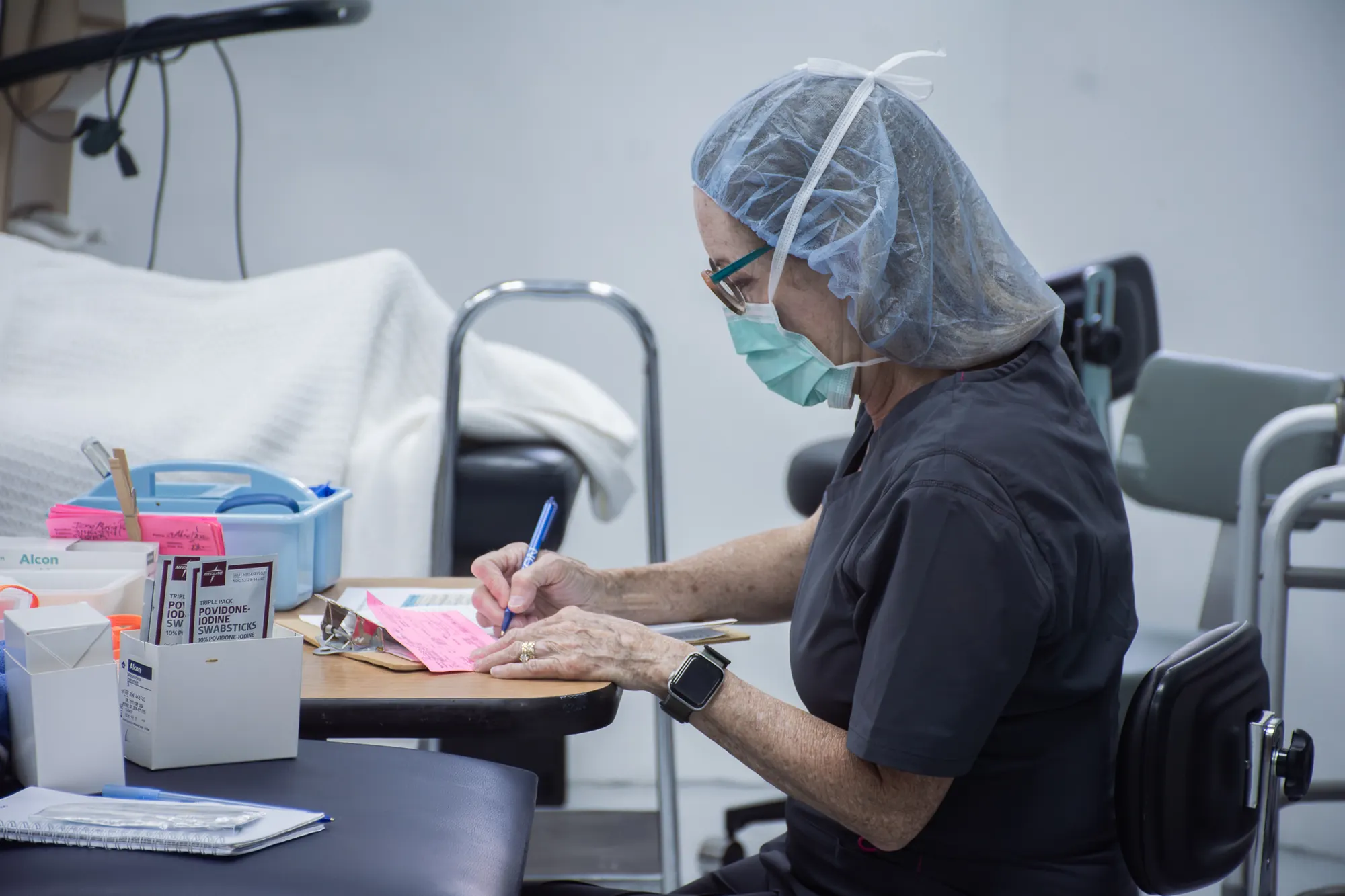 Un voluntario médico prepara suministros para un día de cirugía ocular en El Faro.