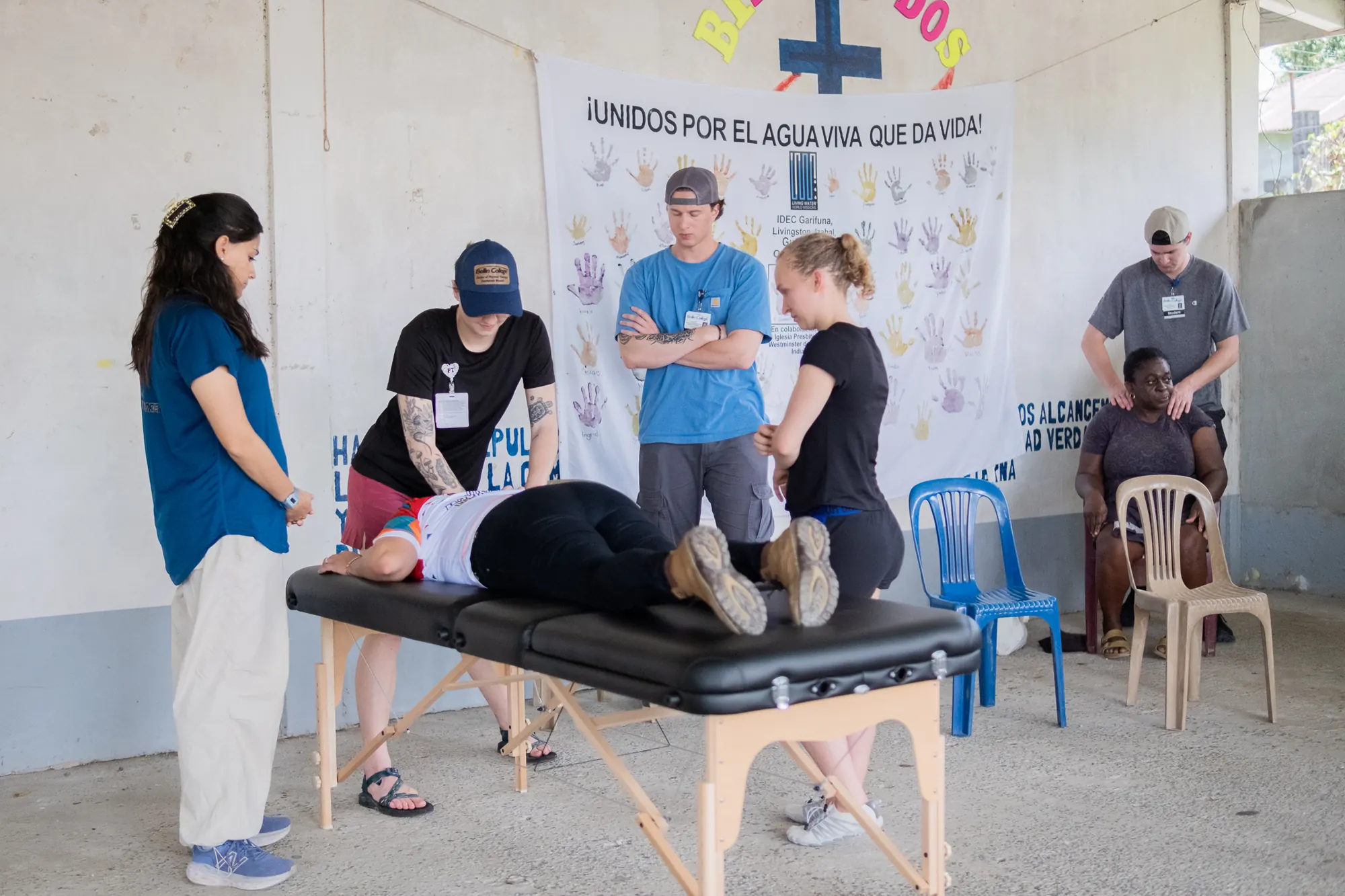 Los voluntarios de atención médica visitantes demuestran una técnica de fisioterapia.