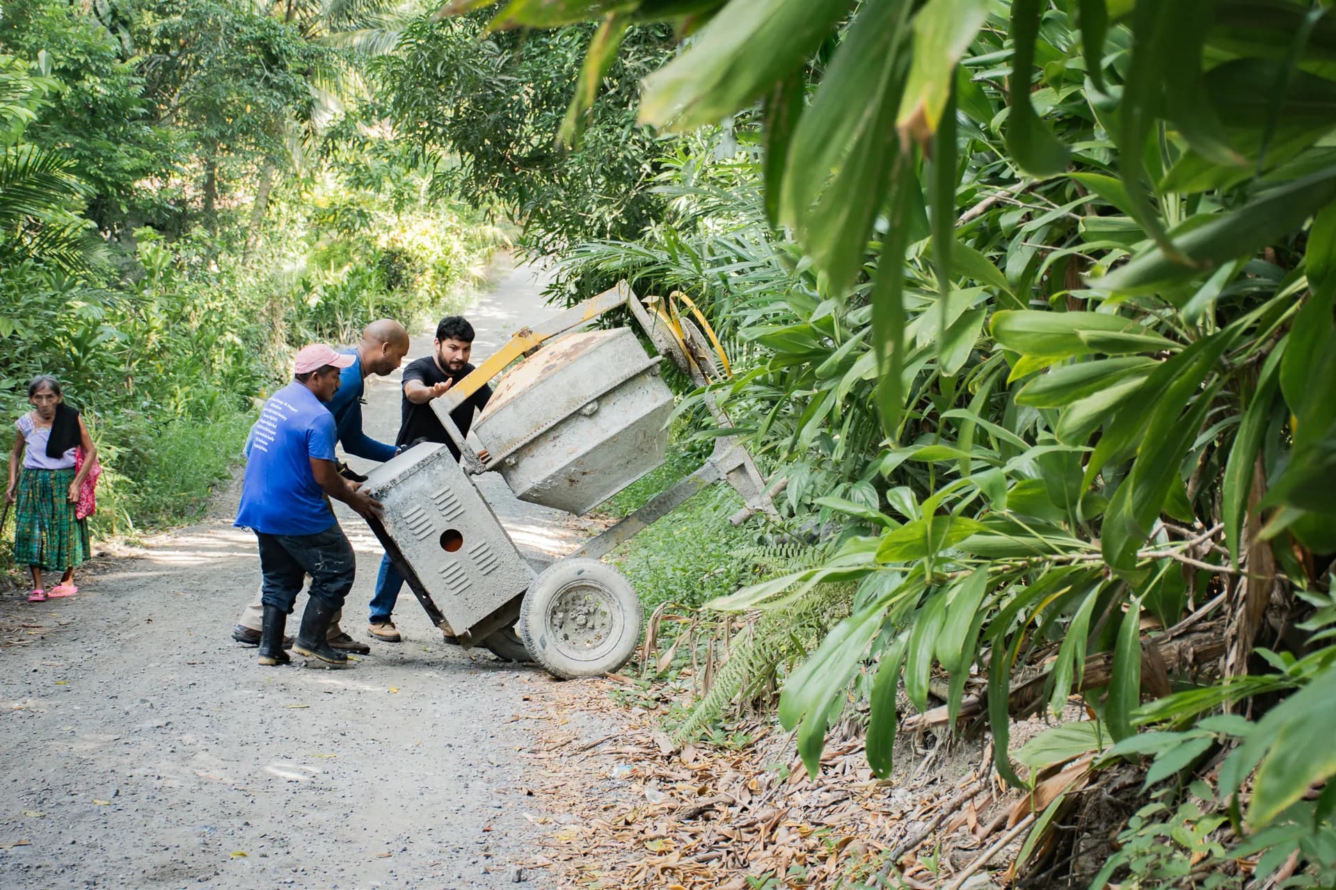 Los miembros del equipo trasladan materiales del proyecto a lo largo de un sendero tropical en Izabal, Guatemala.