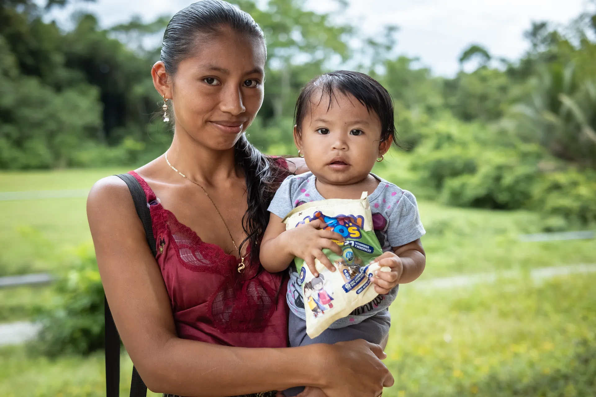 A mother holds her young child during an El Faro nutrition program.
