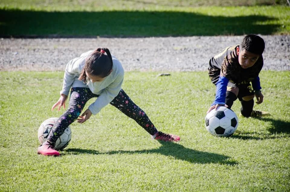 Niños juegan al fútbol en el campus de El Faro.