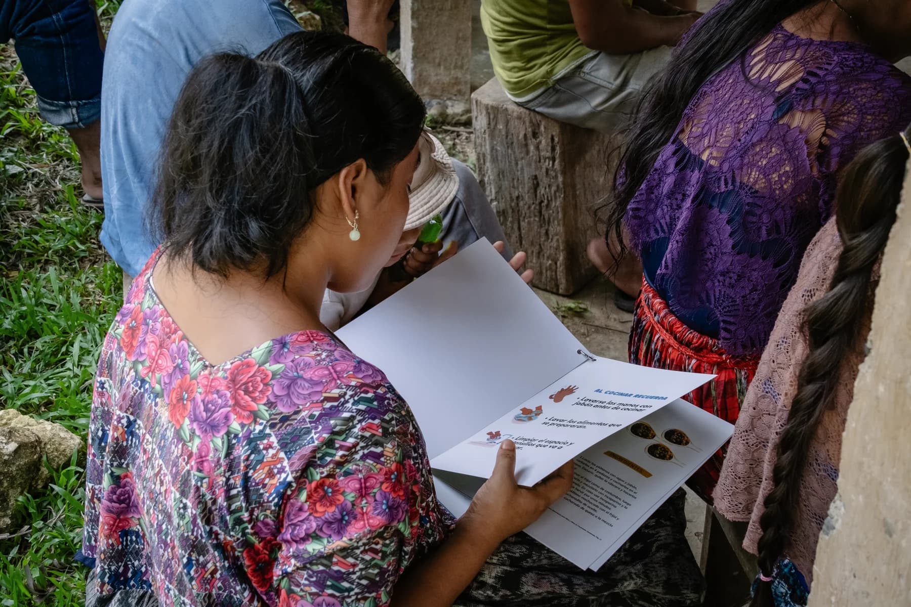 Community members review printed materials in Creek Maya.