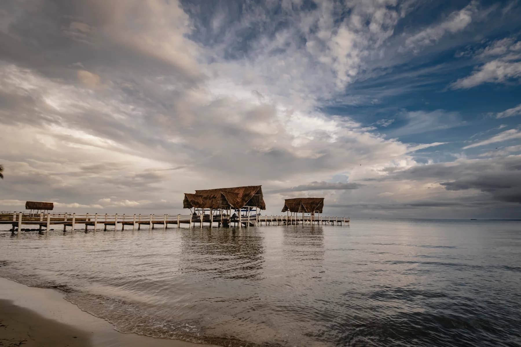El muelle de El Faro bajo un cielo caribeño nublado.