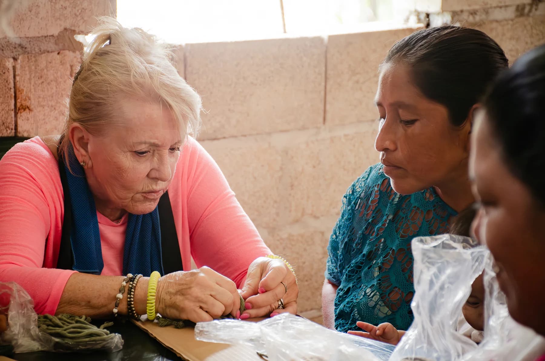 Una voluntaria y una mujer de la comunidad trabajan juntas en una mesa.