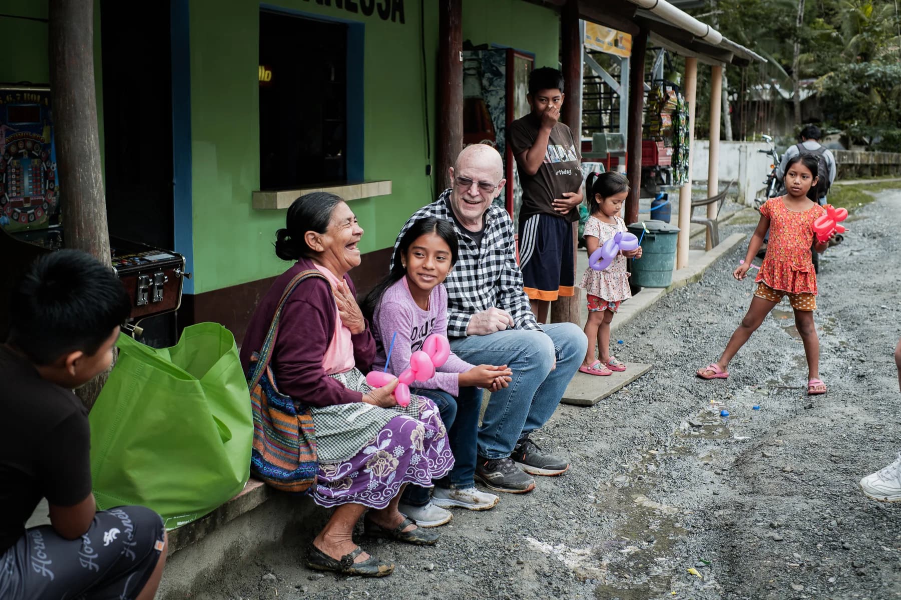 Visitantes y residentes comparten tiempo afuera de una casa.