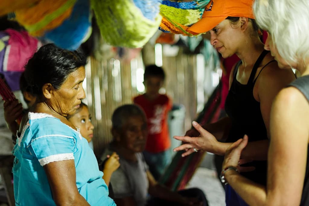 A volunteer talks with a woman during a home visit.