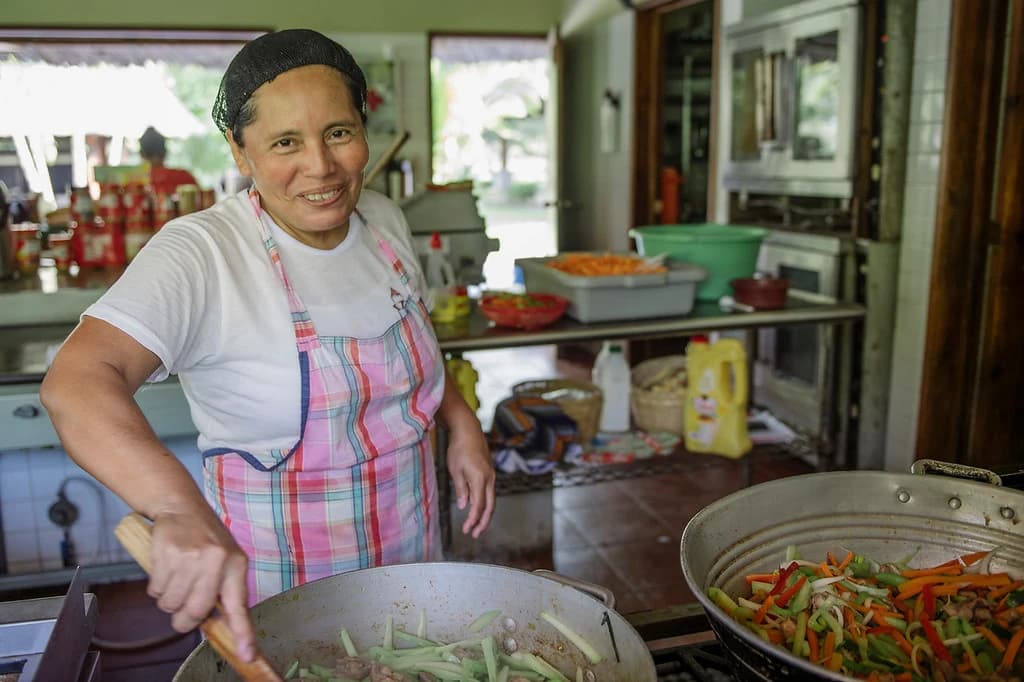 Una integrante del equipo de hospitalidad de El Faro prepara alimentos.